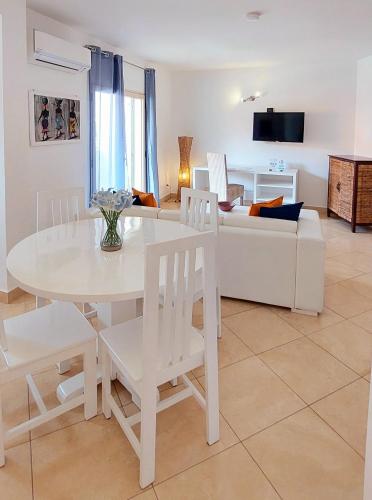 a living room with a white table and chairs and a couch at Branco Suites - Rooms & Holiday Apartments in Santa Maria