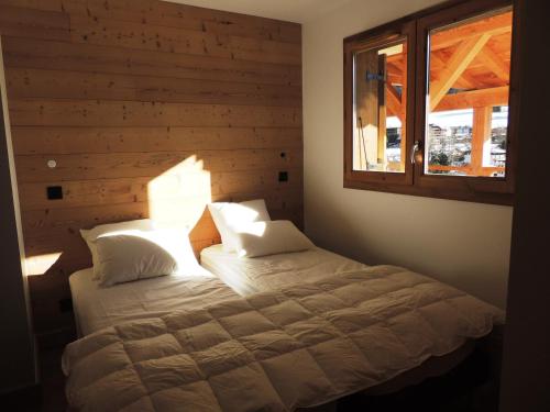Schlafzimmer mit einem Bett und einem Fenster in der Unterkunft Appartement Les Gets, 4 pièces, 6 personnes - FR-1-598-53 in Les Gets