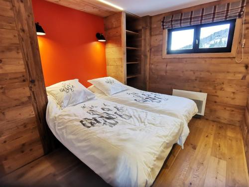 a bedroom with a bed in a wooden room at Appartement de Charme 4* au Centre des Gets - Accès Direct aux Pistes de Ski - FR-1-598-28 in Les Gets