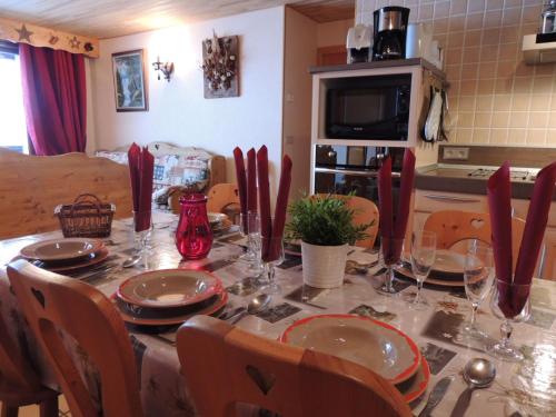- une table avec des assiettes et des verres dans la cuisine dans l'établissement Les Gets : Appt 10 pers skis aux pieds, balcon, parking, wifi - FR-1-598-72, aux Gets