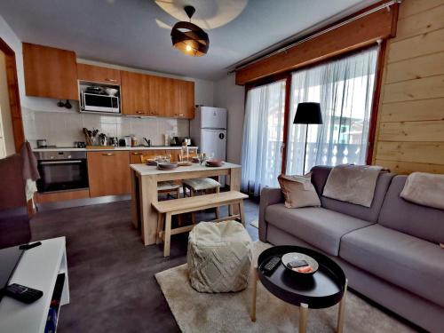 un salon avec un canapé et une cuisine dans l'établissement Appartement lumineux rénové, 35 m², proche pistes et centre, 4 pers, terrasse et garage, Les Gets - FR-1-598-38, aux Gets