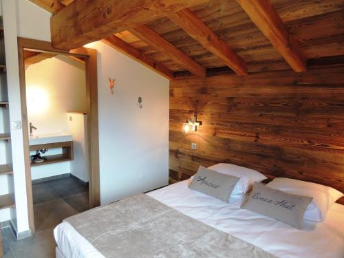 1 Schlafzimmer mit Holzwänden und 1 Bett mit 2 Kissen in der Unterkunft Appartement Les Gets, 4 pièces, 8 personnes - FR-1-598-11 in Les Gets