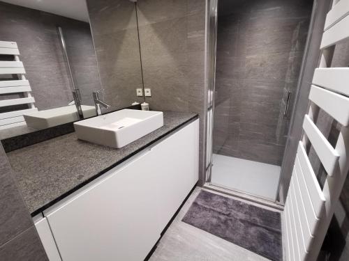 une salle de bain avec un lavabo et une douche dans l'établissement Appartement neuf 54m² Les Gets, centre, balcon sud-ouest, Wifi, parking - FR-1-598-70, aux Gets