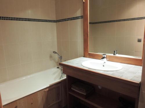 a bathroom with a sink and a tub and a mirror at Appartement Les Gets, 3 pièces, 6 personnes - FR-1-598-71 in Les Gets