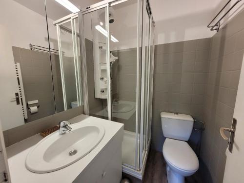 une salle de bain avec un lavabo, des toilettes et une douche dans l'établissement Appartement skis aux pieds avec piscine, rénové et confortable - FR-1-598-18, aux Gets