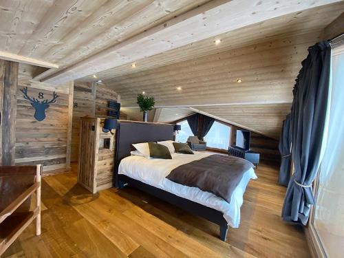 sypialnia z łóżkiem i drewnianym sufitem w obiekcie Chalet Les Gets, 5 pièces, 14 personnes - FR-1-598-19 w mieście Les Gets