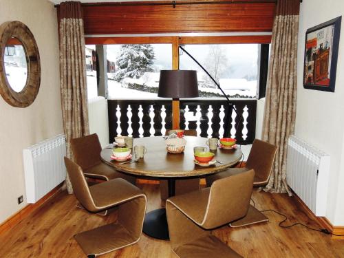 une salle à manger avec une table et des chaises et une fenêtre dans l'établissement Appartement de Luxe 6 Pièces Pied des Pistes au Centre du Village - Les Gets - FR-1-598-26, aux Gets