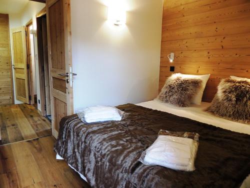 une chambre avec un grand lit dans une pièce dans l'établissement Charmant triplex 3* avec parking, WiFi, proche centre village - FR-1-598-32, aux Gets