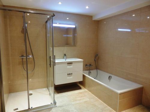 a bathroom with a shower and a sink and a tub at Grand appartement familial avec garage et WiFi, 3 chambres pour 8 personnes - FR-1-598-55 in Les Gets