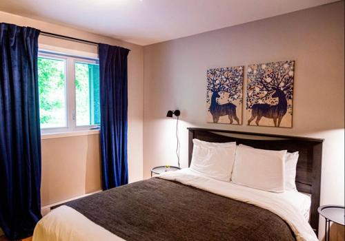 um quarto com uma cama e duas pinturas na parede em Hotels Hébert em Bécancour