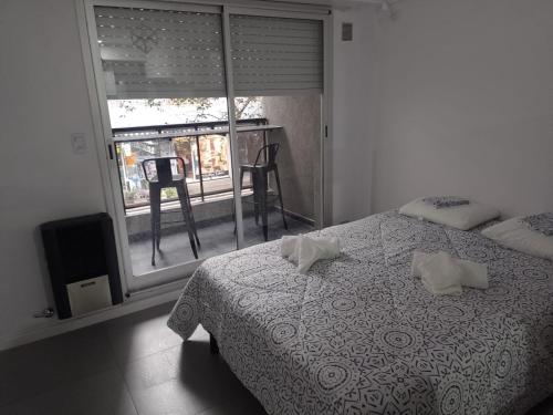 una camera da letto con un letto con due cuscini e una finestra di Alquiler Temporario Rosario 4 a Rosario