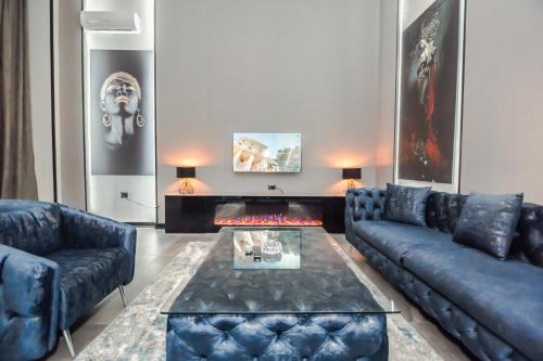 a living room with blue couches and a fireplace at VIP APARTMENT FRANCE EMBASSY in Baku