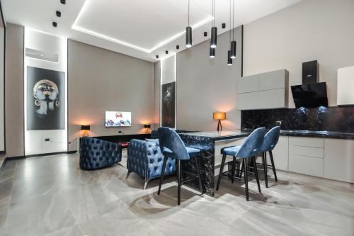 a kitchen with blue chairs and a table in a room at VIP APARTMENT FRANCE EMBASSY in Baku