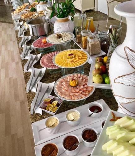 Un buffet con muchos platos de comida en una mesa. en Lindo apartamento na praia brava, en Florianópolis