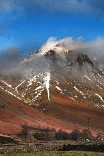 a snow covered mountain with a misty mountain at Strands Hotel/Screes Inn & Micro Brewery in Nether Wasdale