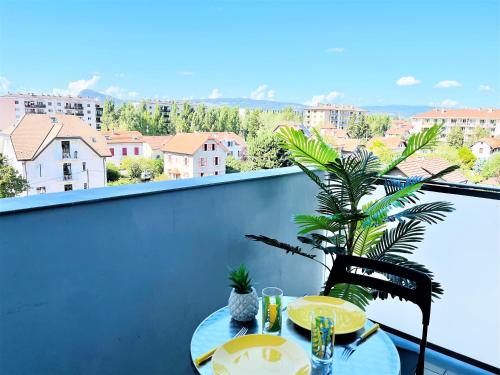 une table sur un balcon avec vue sur une ville dans l'établissement Le Bellevue à 10min du centre à pied, à Annecy