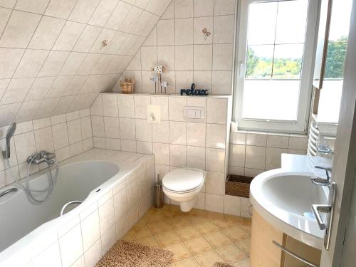 ein Badezimmer mit einer Badewanne, einem WC und einem Waschbecken in der Unterkunft Ferienhaus Rupnow Plau am See in Plau am See