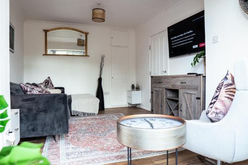 a living room with a couch and a table at Large 4 BedroomProperty driveway and 3 bathrooms in Burton Latimer
