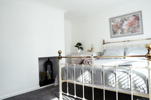 1 dormitorio con cama de metal y paredes blancas en Large 4 BedroomProperty driveway and 3 bathrooms en Burton Latimer