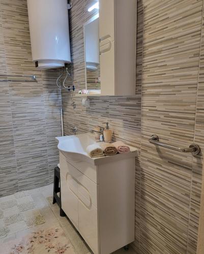 a bathroom with a sink and a mirror at Apartmani Lux in Trebinje