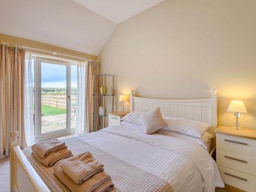 a bedroom with a large white bed with towels on it at The Parlour - Uk36122 in Horsington