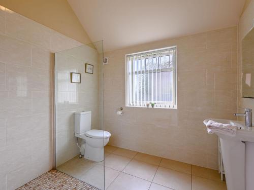 a bathroom with a toilet and a sink and a window at The Parlour - Uk36122 in Horsington