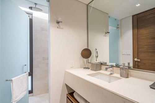 a bathroom with a sink and a mirror at Amazing Cabo Marina condo with private jacuzzi in Cabo San Lucas