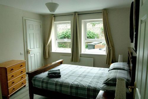 a bedroom with a bed and two windows at Donard Holidays in Newcastle
