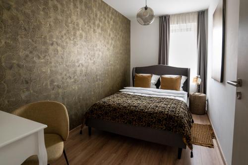 1 dormitorio con cama y pared en Cesar Apartman, en Sopron