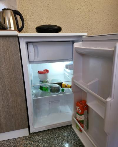 a white refrigerator with its door open in a kitchen at Apartmani Lux in Trebinje
