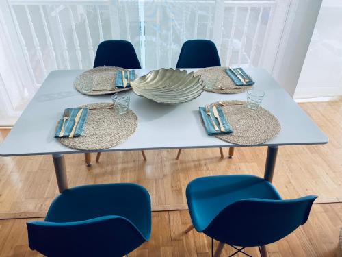 uma mesa azul com cadeiras e pratos em Apartamento Costa del Sol Suances em Suances