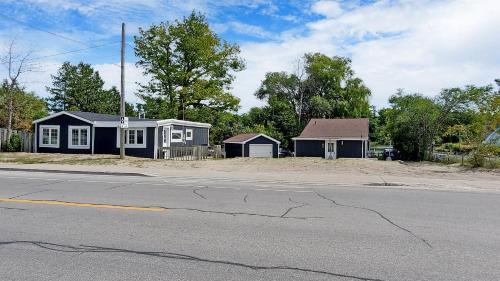 a small house sitting on the side of a street at Main Beach River Retreat - Wasaga Beach 1 - Main Strip - 93 Mosley St in Wasaga Beach