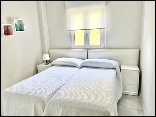 1 dormitorio blanco con 1 cama blanca y 2 ventanas en Mi Capricho 2B1 Beachfront Complex-Apartment Beachside With sea views, en Mijas Costa