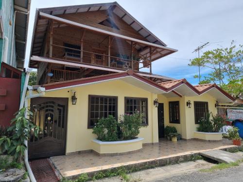 a house with a balcony on top of it at Hostal Bocas Tropical Paradise in Bocas del Toro