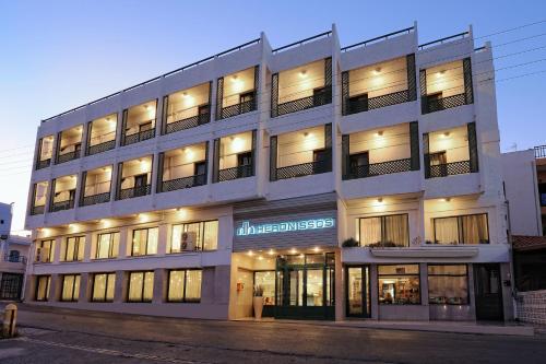 
a large white building with a large window at Heronissos Hotel in Hersonissos
