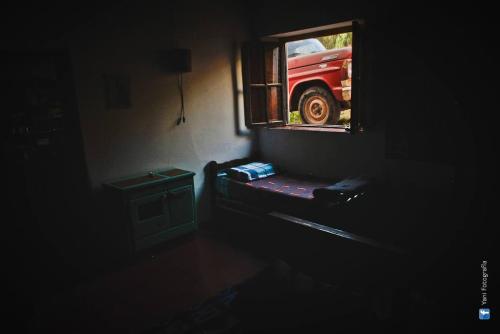 a dark room with a window and a red car at Casamolle Hostel in Tilcara