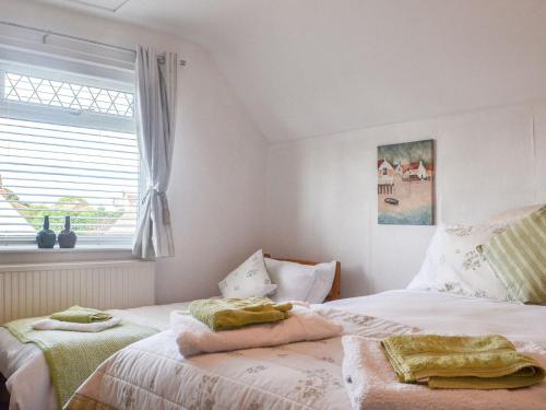 a bedroom with two beds and a window at Highpool House in The Mumbles