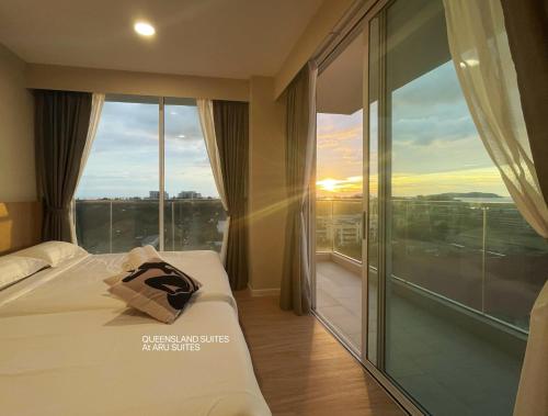 a hotel room with a bed and a large window at QUEENSLAND SUITES at Aru Suites, Kota Kinabalu in Kota Kinabalu