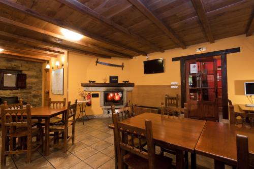a restaurant with tables and chairs and a fireplace at Posada Casa Rosalia in Sámano