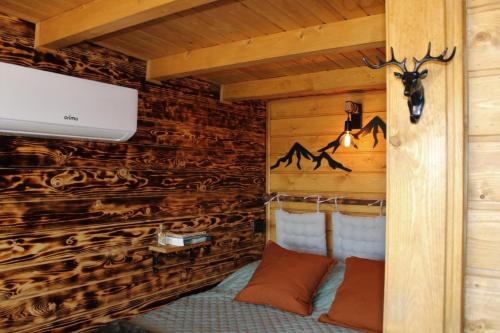 a room in a log cabin with a bed and a tv at Lagoon Tiny House in Arcos de Valdevez
