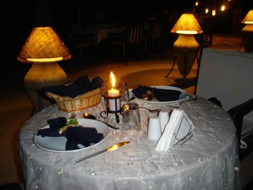 a table with plates of food on it with two lamps at Misafir Evi in Kayakoy