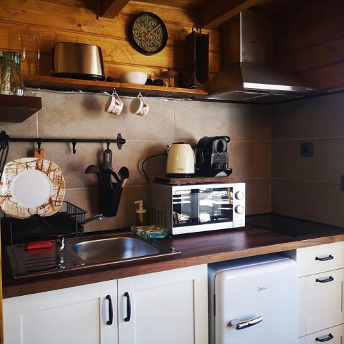 a kitchen with a microwave and a sink at Bungalow Lagoas de Grade in Arcos de Valdevez