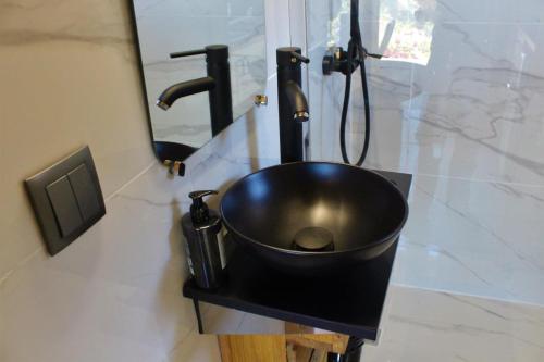a black sink in a bathroom with a mirror at Lagoon Tiny House in Arcos de Valdevez