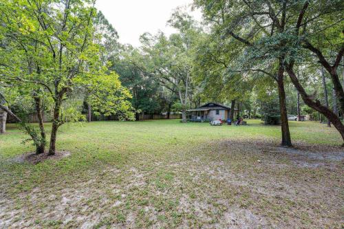 a park with trees and a house in the distance at Moody Woods in Orange Park