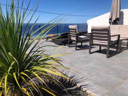 two chairs and a table on a patio at Calheta Ocean View Apartment 2 - Air Condition in Estreito da Calheta