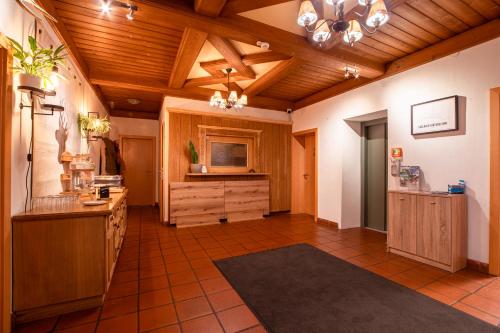 a large kitchen with wooden ceilings and wooden cabinets at Gasthof Alpensport in Saalbach-Hinterglemm