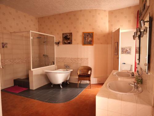 une salle de bain avec une baignoire et un lavabo et une baignoire dans l'établissement Les Volets Bleus, à Sallèles-dʼAude