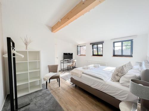 ein Schlafzimmer mit einem großen Bett und einem Schreibtisch in der Unterkunft SEEBADHOF Berlin-Rangsdorf in Rangsdorf