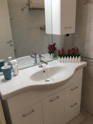 uma casa de banho com um lavatório branco e um espelho. em Via Bellaria em San Lazzaro di Savena