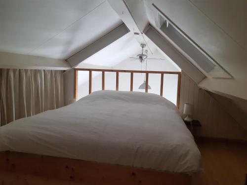 a bedroom with a white bed with a window at De Steegberg Holiday Home in Sevenum